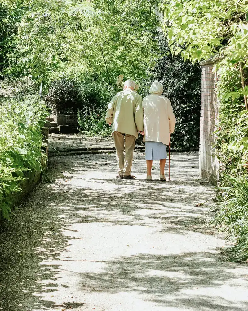 Betreuerin begleitet eine Seniorin beim Spaziergang in Herford